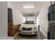 Attached garage featuring white Nissan car, water heater, storage boxes and carpet roll at 336 N 168Th Dr, Goodyear, AZ 85338