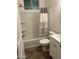 Clean bathroom with shower-tub combo, wood-look tile, updated cabinets and shower curtain at 3480 E Sheffield Rd, Gilbert, AZ 85296