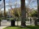 Park with benches, mature trees, playground equipment, and trash receptacle at 3480 E Sheffield Rd, Gilbert, AZ 85296