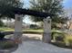 Arched entrance to the green space with brick columns and black wooden pergola at 3480 E Sheffield Rd, Gilbert, AZ 85296