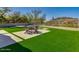 Inviting backyard features artificial grass, pavers, seating area and perimeter fencing for relaxing or entertaining at 3634 N Desert Oasis --, Mesa, AZ 85207