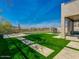 Serene backyard featuring artificial grass, pavers, perimeter fencing, and picturesque views of the surrounding landscape at 3634 N Desert Oasis --, Mesa, AZ 85207