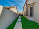 Long, narrow backyard features artificial turf, stone walkway, and tall privacy wall at 3634 N Desert Oasis --, Mesa, AZ 85207
