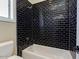 Modern bathroom with black tiled shower and a white bathtub under a window at 3634 N Desert Oasis --, Mesa, AZ 85207