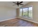 Bright bedroom features wood floors, ceiling fan, and a large picture window with scenic outdoor views at 3634 N Desert Oasis --, Mesa, AZ 85207