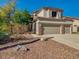 Charming beige two-story home with a three-car garage and desert landscaping in the front yard at 3634 N Desert Oasis --, Mesa, AZ 85207