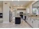 Bright kitchen with white cabinets, a black island, and marble floors, offering a stylish and functional space at 3634 N Desert Oasis --, Mesa, AZ 85207