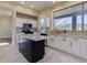 Bright kitchen with white cabinets, a black island, and marble floors, offering a stylish and functional space at 3634 N Desert Oasis --, Mesa, AZ 85207