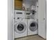 Bright laundry room with a washer, dryer, storage cabinet, shelf and containers at 36562 W Nina St, Maricopa, AZ 85138