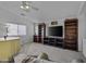 Bright and airy living room with a ceiling fan, plush seating, and a large television at 36562 W Nina St, Maricopa, AZ 85138