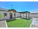 Backyard features artificial turf, pavers, rock landscaping, and a covered patio and entry area at 3831 N 8Th St, Phoenix, AZ 85014