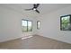 Bright bedroom with laminate floors, a modern ceiling fan, and three windows at 3831 N 8Th St, Phoenix, AZ 85014