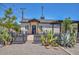 Attractive single-story home with desert landscaping, a dark wooden fence, and a covered entrance, adding character at 3831 N 8Th St, Phoenix, AZ 85014