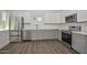 Well-lit kitchen features stainless steel appliances, ample countertop space, modern cabinets, and wood-look flooring at 3831 N 8Th St, Phoenix, AZ 85014