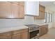 Kitchen area featuring an oven with a hood, wooden cabinets with gold hardware, and white countertops at 3831 N 8Th St, Phoenix, AZ 85014