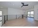 Spacious loft area with modern railing, wood-look floors, black ceiling fan, and natural light from the windows at 3831 N 8Th St, Phoenix, AZ 85014