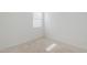 Bright bedroom showing neutral carpet, window, and baseboards at 40060 W Wade Dr, Maricopa, AZ 85138
