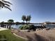 Scenic view of the community lake with lush landscaping, rock features, and waterfront homes in the background at 40060 W Wade Dr, Maricopa, AZ 85138