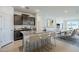 Modern kitchen with dark cabinets, granite countertops, stainless steel appliances, and an island with seating at 40060 W Wade Dr, Maricopa, AZ 85138