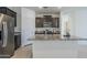 Beautiful kitchen with dark cabinets, granite countertops, stainless steel appliances, and a functional island at 40060 W Wade Dr, Maricopa, AZ 85138