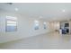 Open-concept living room with neutral walls, tile flooring, and multiple windows providing natural light at 40060 W Wade Dr, Maricopa, AZ 85138