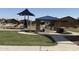 Gathering-friendly community playground with a picnic shelter, play equipment, and open green space at 40060 W Wade Dr, Maricopa, AZ 85138