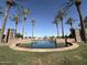 Attractive community water feature with fountains, stone accents, and palm tree landscaping under a clear blue sky at 40060 W Wade Dr, Maricopa, AZ 85138