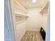 Walk-in closet with built-in shelving and laminate flooring at 4303 E Cactus Rd # 135, Phoenix, AZ 85032