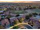 Overhead view of a golf community highlighting the meticulously maintained greens, pools, and beautifully lit homes at 4906 S Verbena Ave, Gilbert, AZ 85298