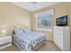 Bedroom featuring a ceiling fan, window with blinds, TV and floral bedding at 4906 S Verbena Ave, Gilbert, AZ 85298