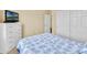 Bedroom with floral bedding, TV, closet and light-colored walls and carpet at 4906 S Verbena Ave, Gilbert, AZ 85298