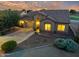 Charming single-story home with desert landscaping, warm lighting, and a two-car garage at dusk at 4906 S Verbena Ave, Gilbert, AZ 85298