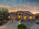 Charming single-story home with desert landscaping, warm lighting, and a two-car garage at dusk at 4906 S Verbena Ave, Gilbert, AZ 85298