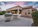 Outdoor kitchen with a built-in grill, bar seating, and a stunning view of the surrounding landscape at sunset at 4906 S Verbena Ave, Gilbert, AZ 85298