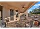 Cozy covered patio features comfortable seating, a ceiling fan, and views of the backyard and golf course at 4906 S Verbena Ave, Gilbert, AZ 85298