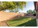 Backyard bordered by a block wall features low-maintenance landscaping and a patch of artificial turf at 689 E Stottler Dr, Gilbert, AZ 85296