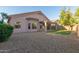 View of the backyard with desert landscaping, a small patch of artificial turf, and a covered patio at 689 E Stottler Dr, Gilbert, AZ 85296