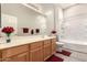 Bathroom featuring wooden cabinets, a long mirror, and a tub with a shower at 689 E Stottler Dr, Gilbert, AZ 85296