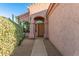 Front entrance features a wooden door, stone pillars, and desert landscaping at 689 E Stottler Dr, Gilbert, AZ 85296