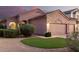 Inviting home exterior featuring a three car garage, desert landscaping, and a touch of artificial grass at 689 E Stottler Dr, Gilbert, AZ 85296