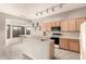 Well-lit kitchen featuring wood cabinets, black appliances, and a breakfast bar at 689 E Stottler Dr, Gilbert, AZ 85296