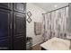 Functional bathroom featuring a sink vanity, a cabinet for extra storage, and a shower with a patterned curtain at 7503 W Julie Dr, Glendale, AZ 85308