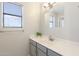 Well-lit bathroom with gray vanity, white countertop, silver fixtures, and a large window at 7503 W Julie Dr, Glendale, AZ 85308