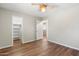 Clean bedroom featuring neutral walls, wood-look flooring, and an open doorway to a walk-in closet at 7503 W Julie Dr, Glendale, AZ 85308