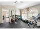 Spacious home gym featuring arched windows, weights, rubber flooring, and inversion table at 7503 W Julie Dr, Glendale, AZ 85308