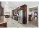 Spacious kitchen with stainless appliances, dark wood cabinets, tile floors, and views into the dining and living areas at 7503 W Julie Dr, Glendale, AZ 85308