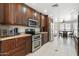 Updated kitchen featuring dark wood cabinets, stainless steel appliances, and tile flooring at 7503 W Julie Dr, Glendale, AZ 85308