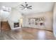 Bright living room featuring a fireplace, ceiling fan, wood floors, and stairs to the second floor at 7503 W Julie Dr, Glendale, AZ 85308