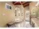 Bright bathroom with a tile floor, neutral walls, a soaking tub, and a single sink vanity at 7722 W Libby St, Glendale, AZ 85308