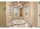 Bathroom featuring a soaking tub surrounded by large windows and views of the outdoors at 7722 W Libby St, Glendale, AZ 85308